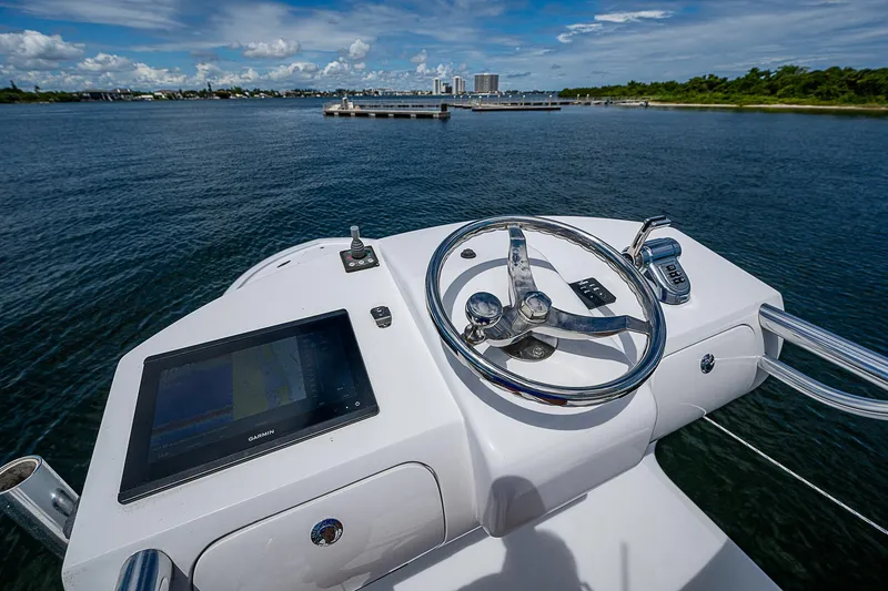 Slide: The Image of Helm of 2011 Winter Custom Yachts 29, featuring steering wheel and navigation screen on open water. - 16