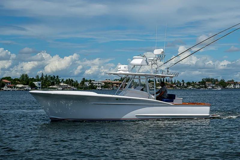Slide: The Image of 2011 Winter Custom Yachts 29 cruising on a calm, scenic waterway under a blue sky. - 17