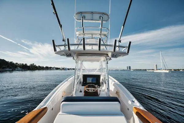 Slide: The Image of 2011 Winter Custom Yachts 29 on calm water, showcasing helm and tower under clear sky. - 26