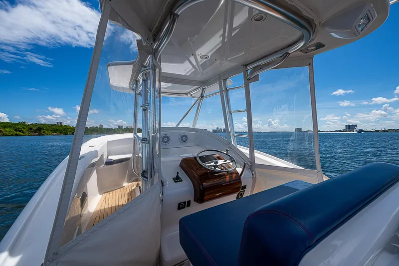 Slide: The Image of 2011 Winter Custom Yachts 29 on water, showcasing helm and seating under clear blue sky. - 15