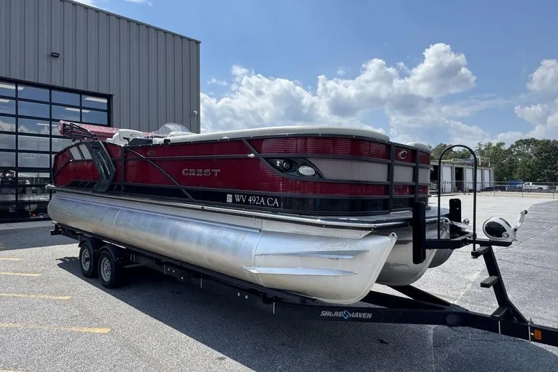 Slide: The Image of 2021 Crest Caribbean Platinum 250 SLS pontoon boat on trailer, parked outdoors. - 1