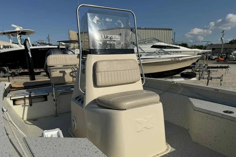 Slide: The Image of 2016 Xpress H20B Bay boat with beige seating, parked in a marina. - 5