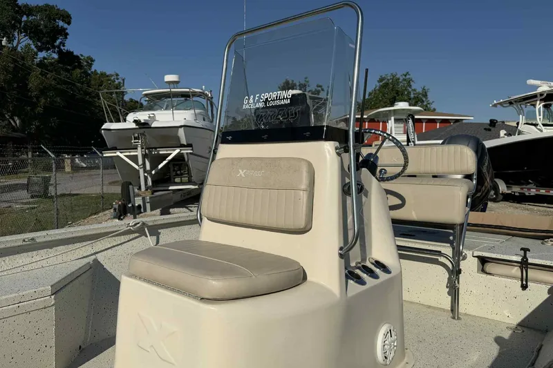 Slide: The Image of 2016 Xpress H20B Bay boat with beige seating and steering console. - 6