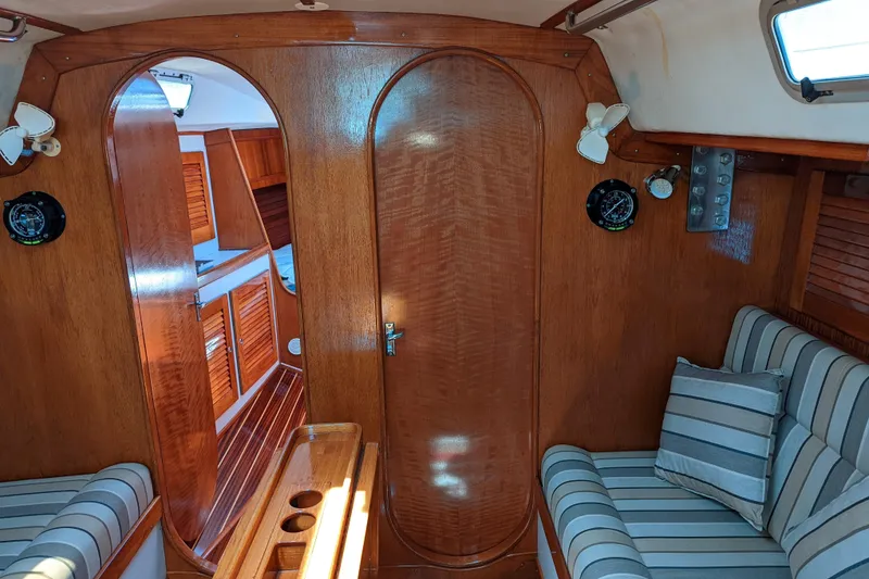 Slide: The Image of Interior of 1993 J Boats J/130 sailboat with wood paneling and striped seating. - 10
