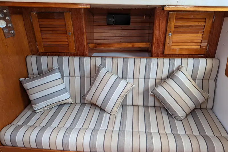 Slide: The Image of Striped sofa with cushions in 1993 J Boats J/130 interior, featuring wooden cabinets. - 12