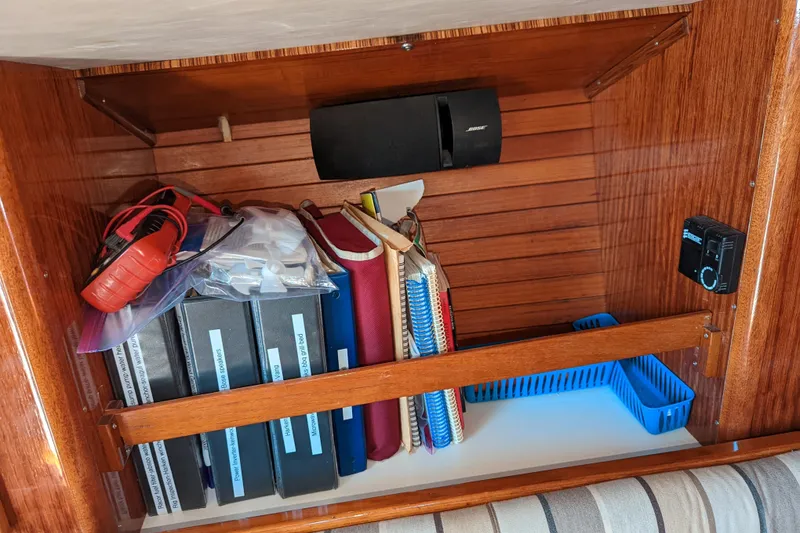 Slide: The Image of Storage shelf on 1993 J Boats J/130 with books, binders, and a speaker. - 16