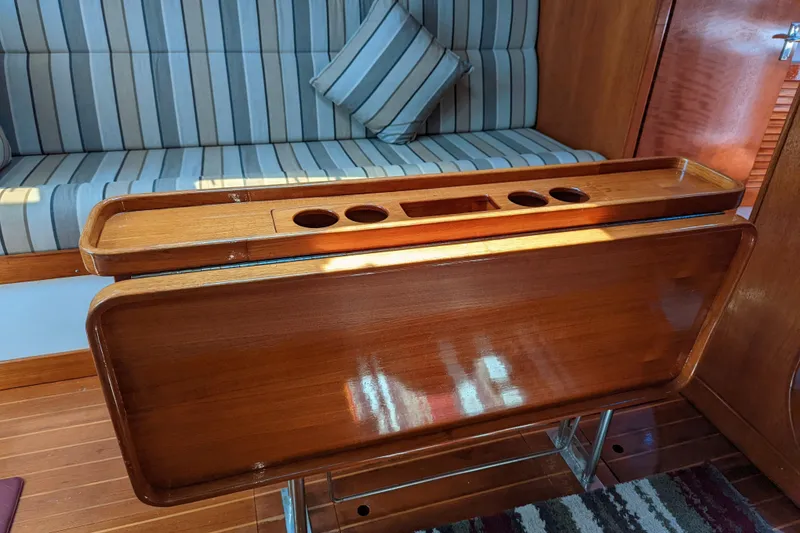 Slide: The Image of Interior of 1993 J Boats J/130 with wooden table and striped seating. - 17