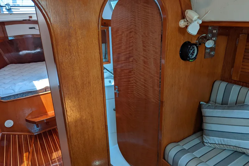 Slide: The Image of Interior of 1993 J Boats J/130 sailboat with wood finish and striped seating. - 31