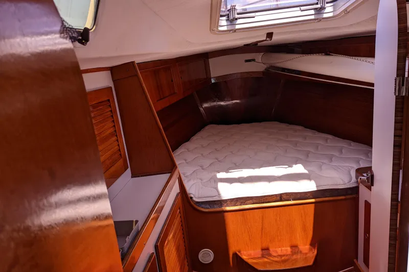 Slide: The Image of 1993 J Boats J/130 cabin interior with wooden finish and cozy bed. - 32