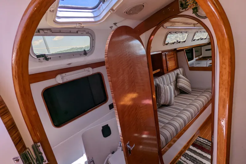 Slide: The Image of Interior of 1993 J Boats J/130 sailboat with striped cushions and wooden finishes. - 36