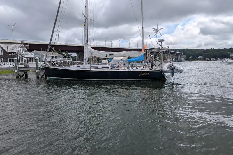 Slide: The Image of Sailboat J/130 from 1993 docked near a bridge under cloudy skies. - 4