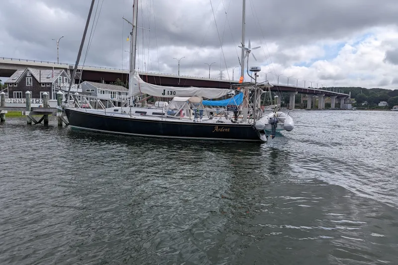 Slide: The Image of 1993 J Boats J/130 sailboat docked near a bridge under cloudy skies. - 8