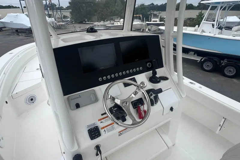 Slide: The Image of 2024 Regulator 26XO boat dashboard with steering wheel and Garmin display. - 6