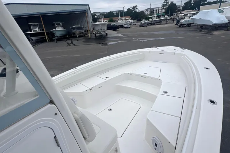 Slide: The Image of 2024 Regulator 26XO boat, spacious deck view at a marina. - 8