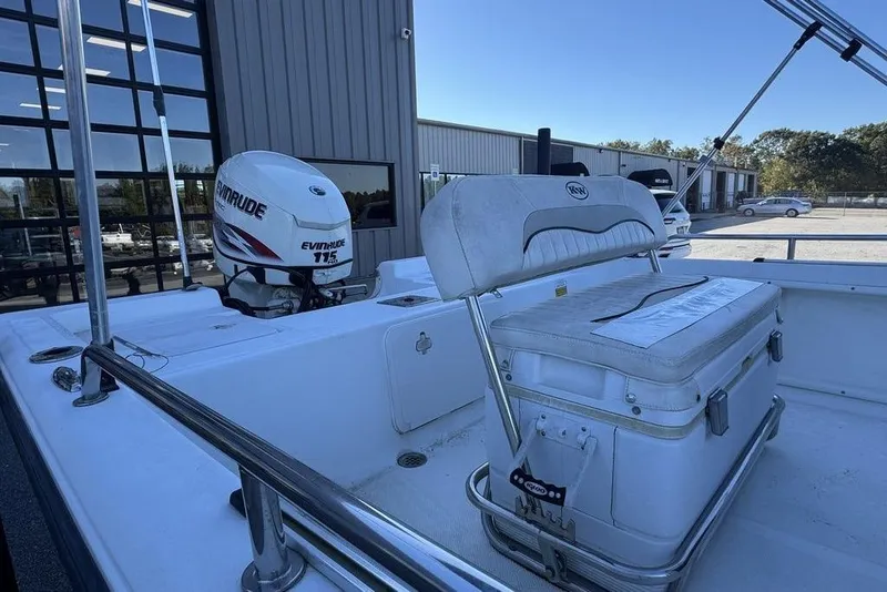 Slide: The Image of 2011 Key West 176 Bay Reef boat with Evinrude 115 engine, docked near industrial buildings. - 11