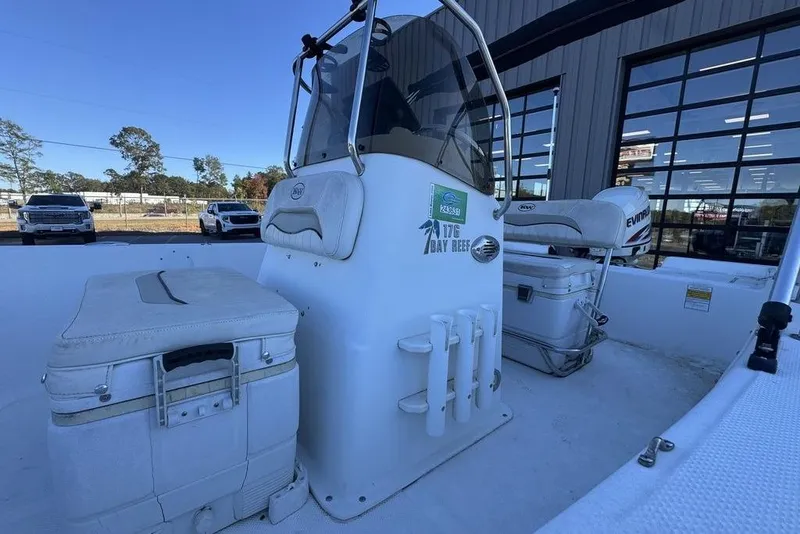 Slide: The Image of 2011 Key West 176 Bay Reef boat interior with seating and storage, parked near a building. - 15