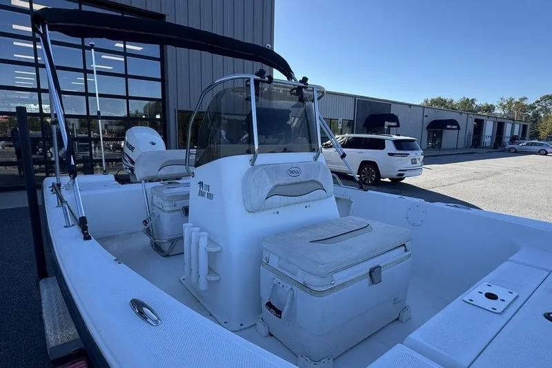 Slide: The Image of 2011 Key West 176 Bay Reef boat with seating and storage, parked outside a building. - 17