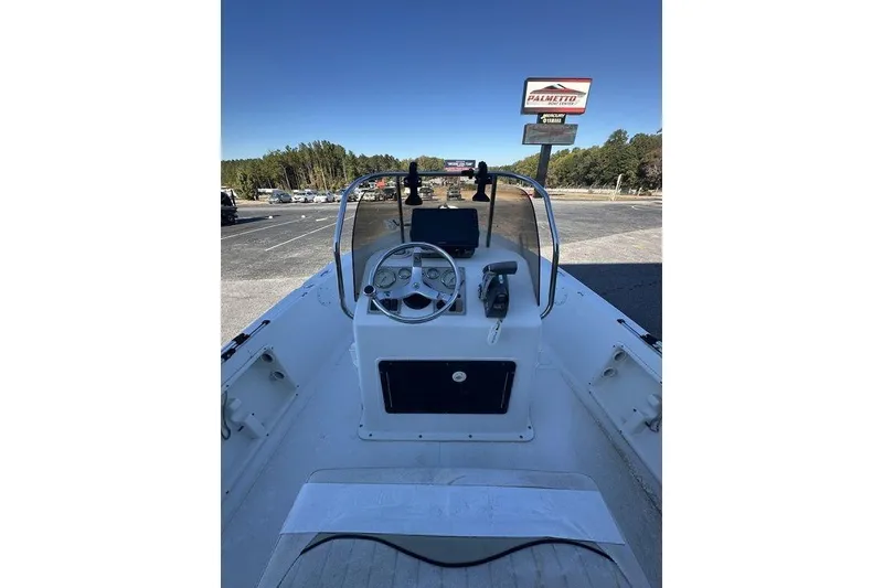 Slide: The Image of 2011 Key West 176 Bay Reef boat interior with steering console and clear sky background. - 6
