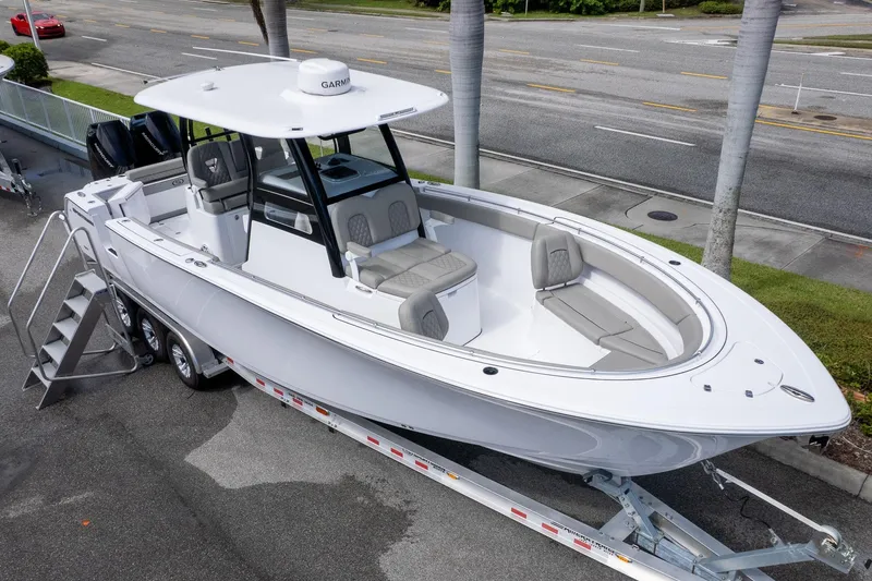The Image of 2025 Sportsman Open 322 Center Console boat on trailer, parked near road. - 0
