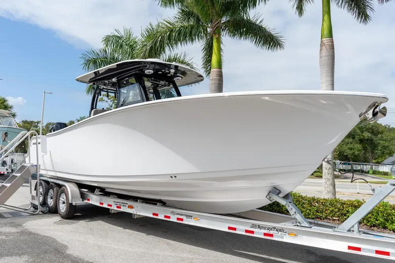 Slide: The Image of 2025 Sportsman Open 322 Center Console boat on trailer, parked near palm trees. - 18