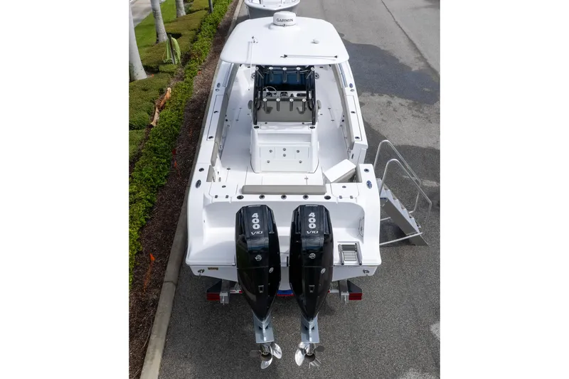 Slide: The Image of 2025 Sportsman Open 322 Center Console boat with dual 400 V10 engines, parked on a street. - 4