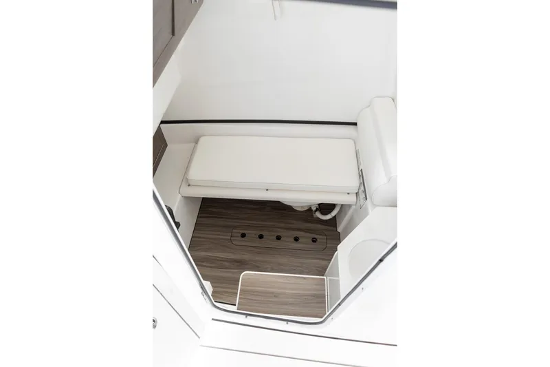 Slide: The Image of 2025 Sportsman Open 322 Center Console interior with cushioned seating and wood-style flooring. - 46