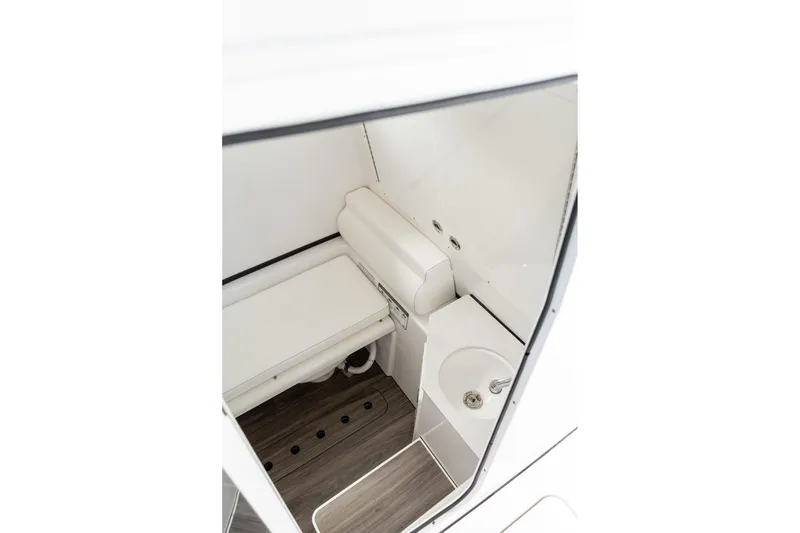 Slide: The Image of 2025 Sportsman Open 322 Center Console interior with compact bathroom and sink. - 47