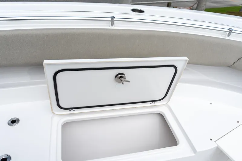 Slide: The Image of 2025 Sportsman Open 322 Center Console storage compartment with open hatch and key lock. - 51