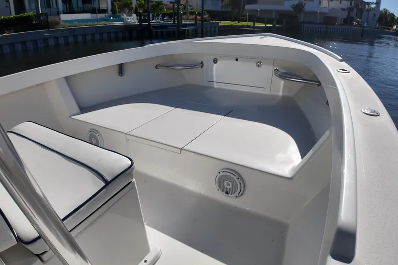 Slide: The Image of 2016 Albury Brothers 23 boat interior with seating and storage, docked by waterfront homes. - 13