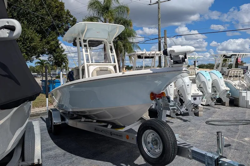 Slide: The Image of 2026 Key West 230 Bay Reef boat on trailer, displayed outdoors under blue sky. - 1