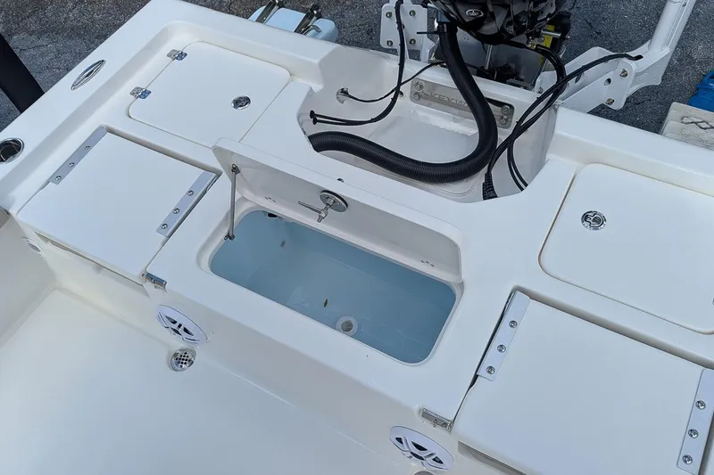 Slide: The Image of 2026 Key West 230 Bay Reef boat deck with storage compartments and speakers. - 10