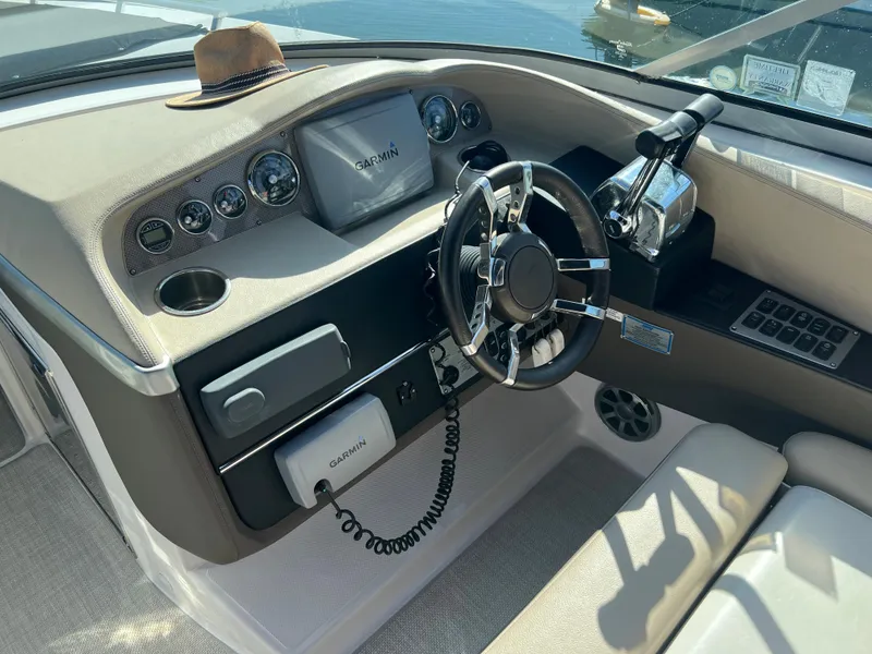 Slide: The Image of 2013 Regal 3200 Bowrider boat dashboard with steering wheel and navigation controls. - 8