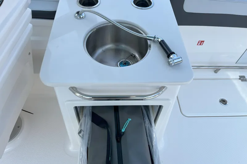 Slide: The Image of 2026 Robalo R257 Dual Console boat sink with storage compartment. - 10