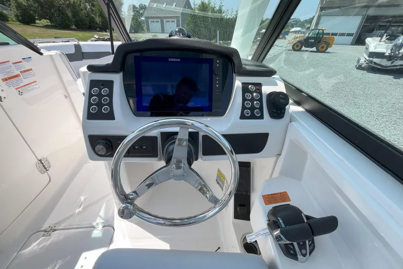 Slide: The Image of 2026 Robalo R257 Dual Console helm with steering wheel and navigation display. - 11