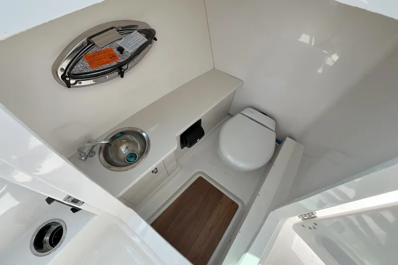 Slide: The Image of 2026 Robalo R257 Dual Console boat interior with toilet and sink. - 14