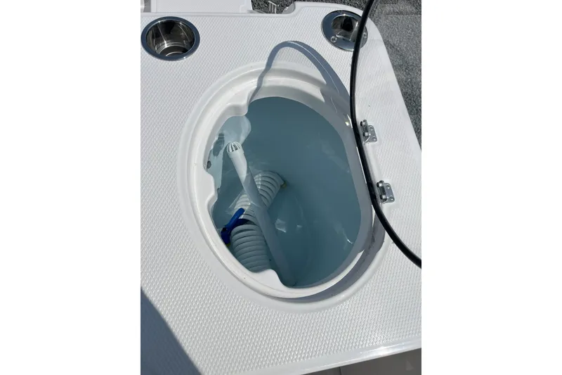 Slide: The Image of Livewell compartment on 2026 Robalo R257 Dual Console boat, featuring integrated cup holder. - 4