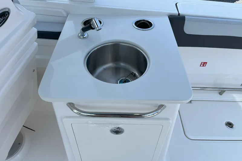 Slide: The Image of 2026 Robalo R257 Dual Console boat sink and faucet on deck. - 9