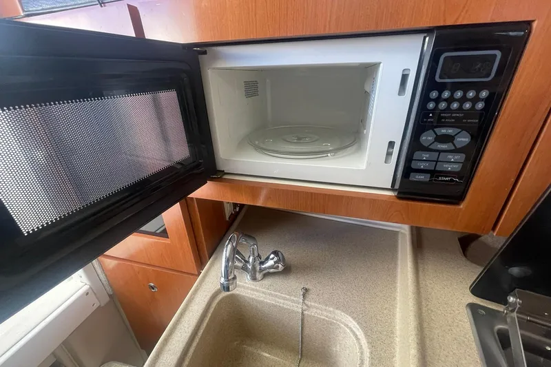 Slide: The Image of Microwave and sink in 2005 Wellcraft 290 Coastal boat kitchen area. - 21