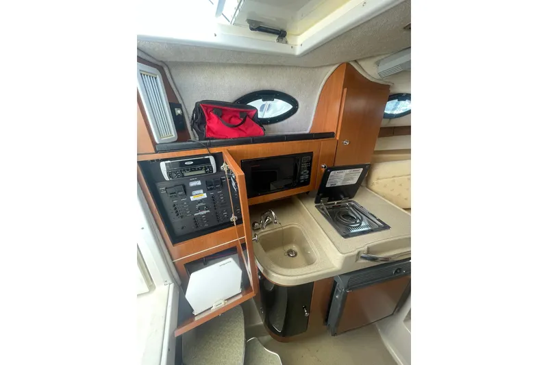 Slide: The Image of 2005 Wellcraft 290 Coastal boat interior with kitchenette, microwave, and sink. - 22