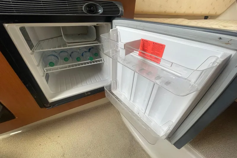 Slide: The Image of Open mini fridge with water bottles inside on a 2005 Wellcraft 290 Coastal boat. - 24