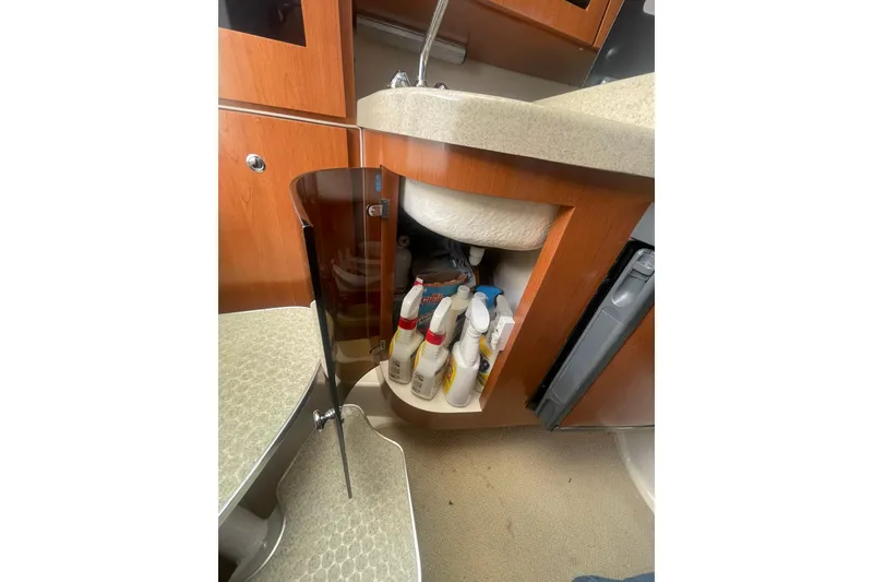 Slide: The Image of 2005 Wellcraft 290 Coastal boat interior with open cabinet and cleaning supplies. - 25