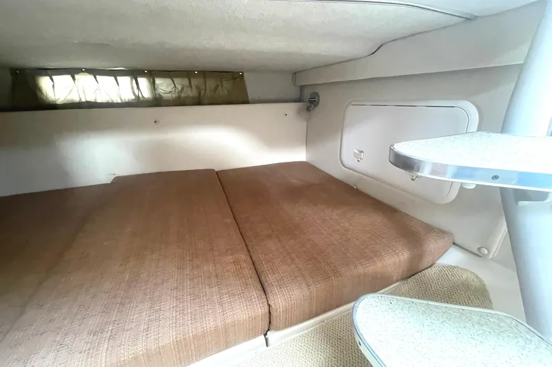 Slide: The Image of 2005 Wellcraft 290 Coastal cabin interior with brown cushions and compact table. - 26