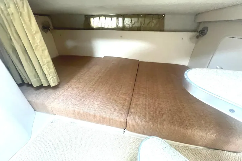Slide: The Image of 2005 Wellcraft 290 Coastal cabin interior with brown cushions and curtains. - 27