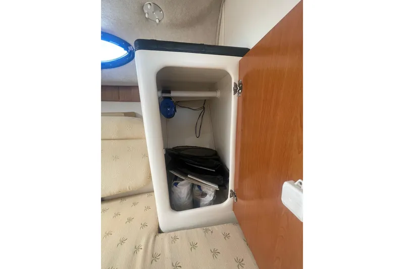 Slide: The Image of 2005 Wellcraft 290 Coastal cabin storage with open wooden door and interior items. - 28