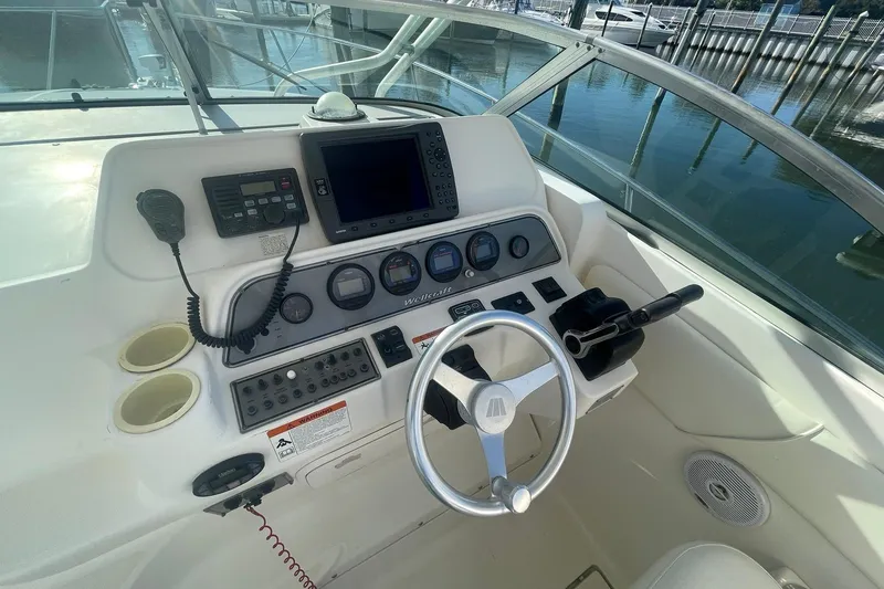 Slide: The Image of 2005 Wellcraft 290 Coastal boat dashboard with steering wheel and navigation controls. - 30