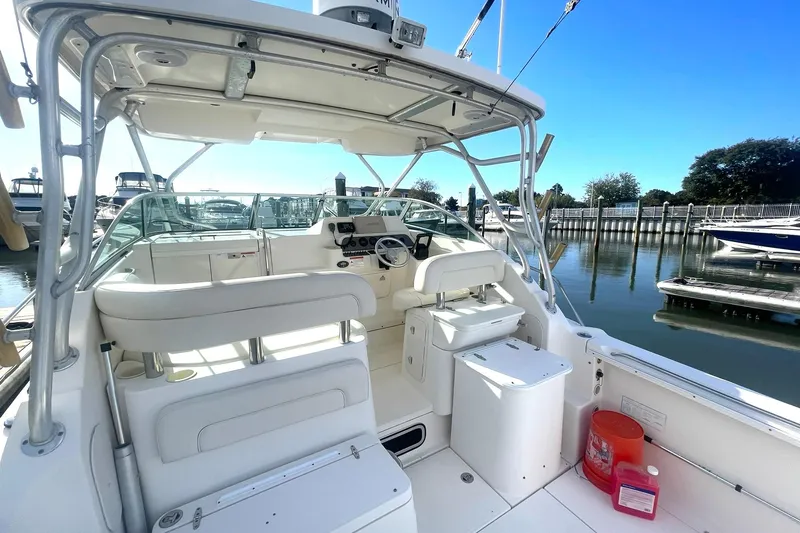 Slide: The Image of 2005 Wellcraft 290 Coastal boat interior, featuring helm and seating, docked at marina. - 37