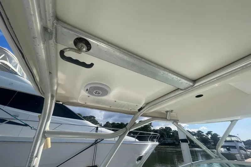 Slide: The Image of 2005 Wellcraft 290 Coastal boat canopy with metal frame and speaker, docked by other boats. - 38