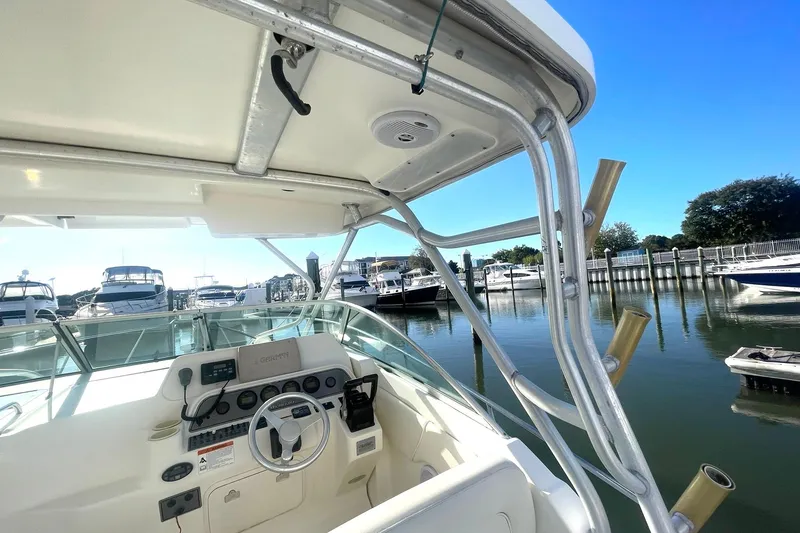 Slide: The Image of 2005 Wellcraft 290 Coastal boat cockpit with marina view, featuring steering wheel and controls. - 39