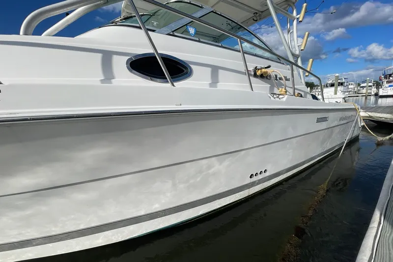 Slide: The Image of 2005 Wellcraft 290 Coastal boat docked, showcasing sleek white hull and modern design. - 44
