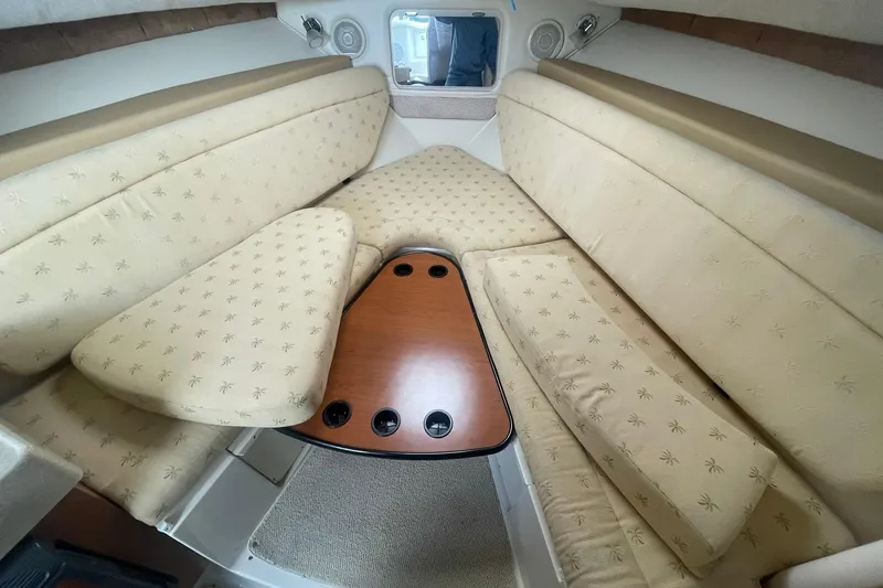 Slide: The Image of 2005 Wellcraft 290 Coastal cabin interior with beige upholstery and wooden table. - 6